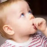 young toddler sucking their thumb