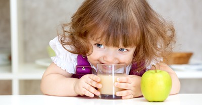 toddler girl drinking from glass