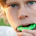 young boy putting in a mouthguard
