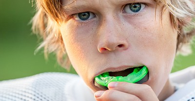 young boy putting in a mouthguard