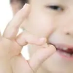 young boy holding his lost tooth
