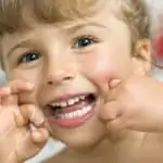 little girl flossing her teeth