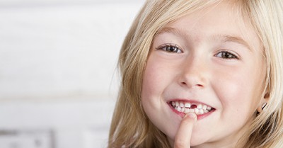 little girl pointing to her missing front tooth