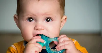 baby chewing on teething ring