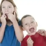 little girl and boy flossing teeth together