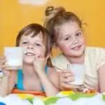 two kids drinking milk