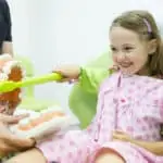 little girl sitting in dental chair