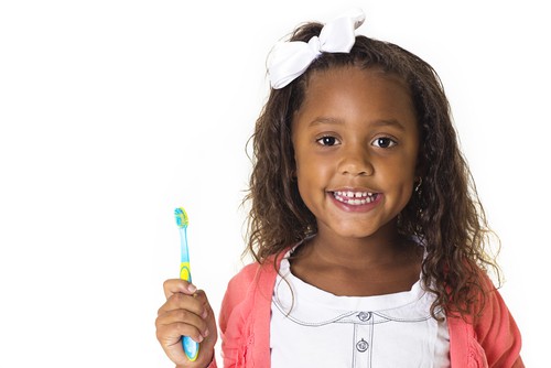 little girl holding toothbrush