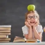 child at school with apple on her head
